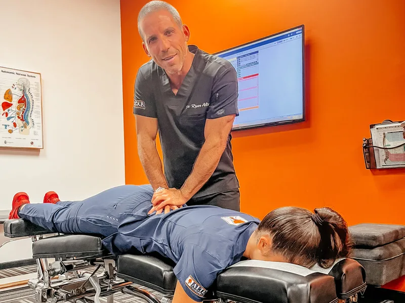 Dr. Ryan Alter treating a patient's hips at Alter Chiropractic in Delray Beach