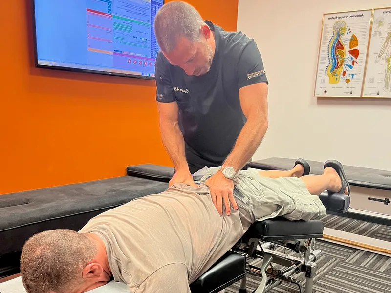Dr. Ryan Alter adjusting a patient's upper back for posture