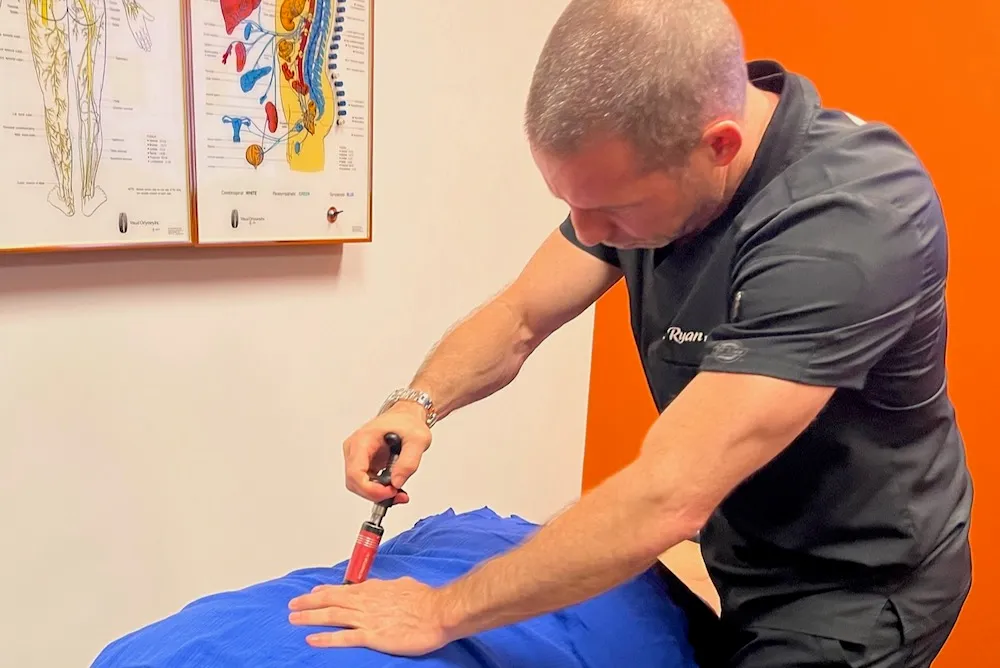 Dr. Ryan Alter adjusting a patient with an Activator instrument