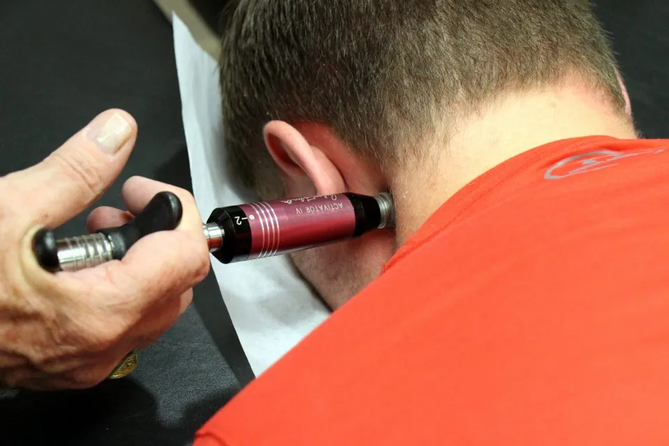 Activator instrument used on a patient’s neck