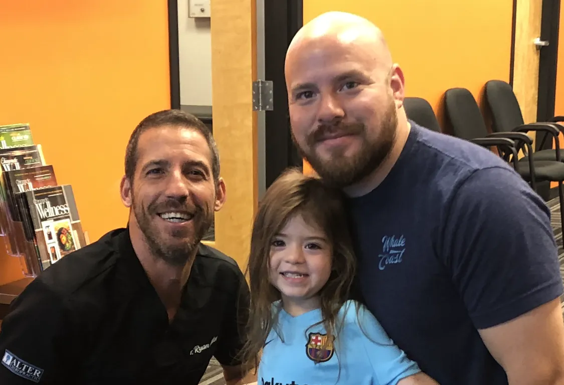 Dr. Ryan Alter with a young girl and her father