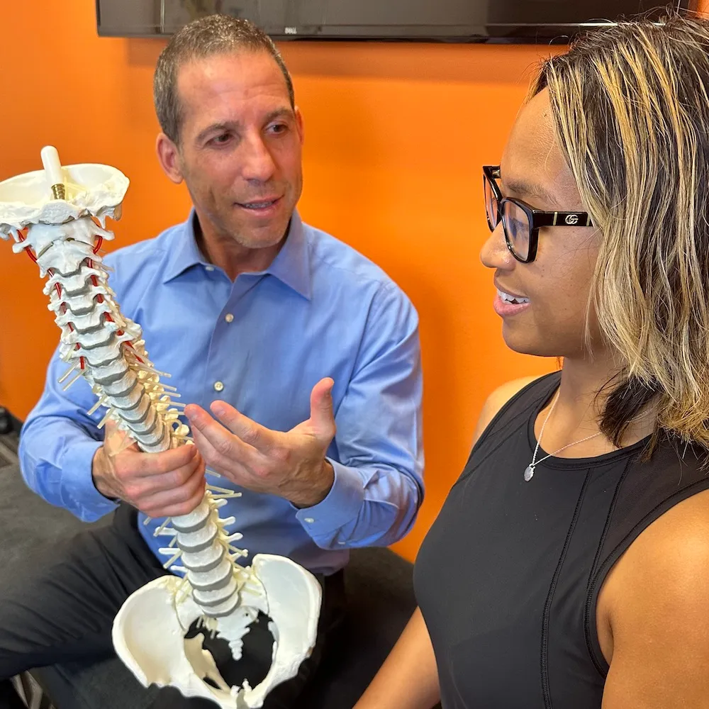 dr ryan showing patient the human spine model