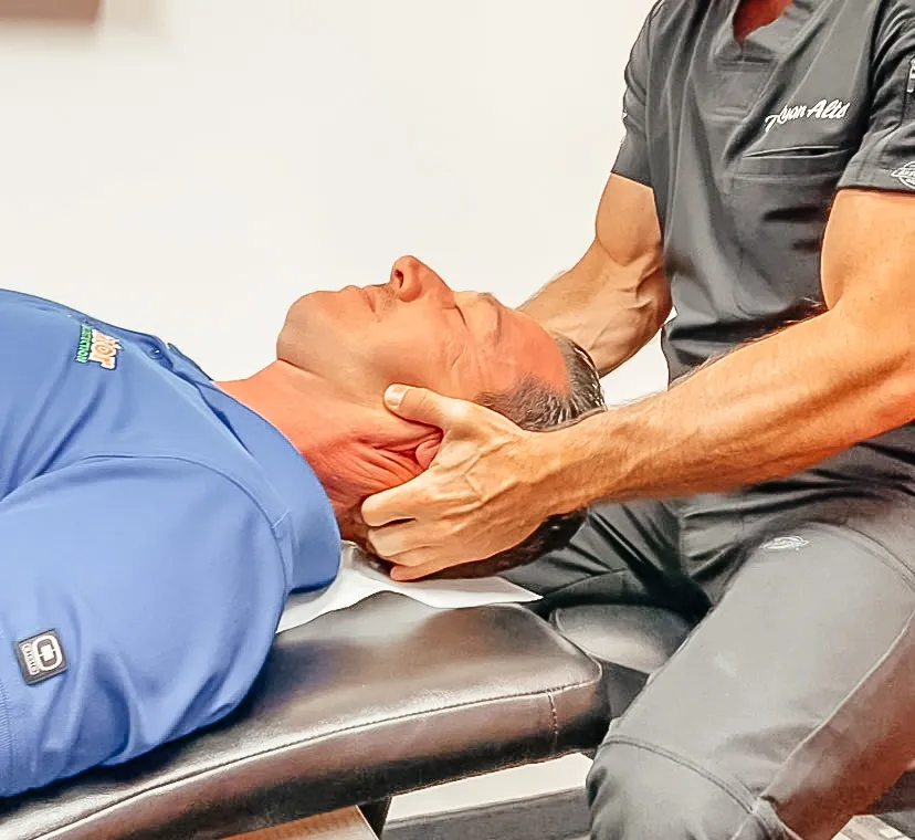 Dr. Ryan Alter supporting a patient's neck during treatment