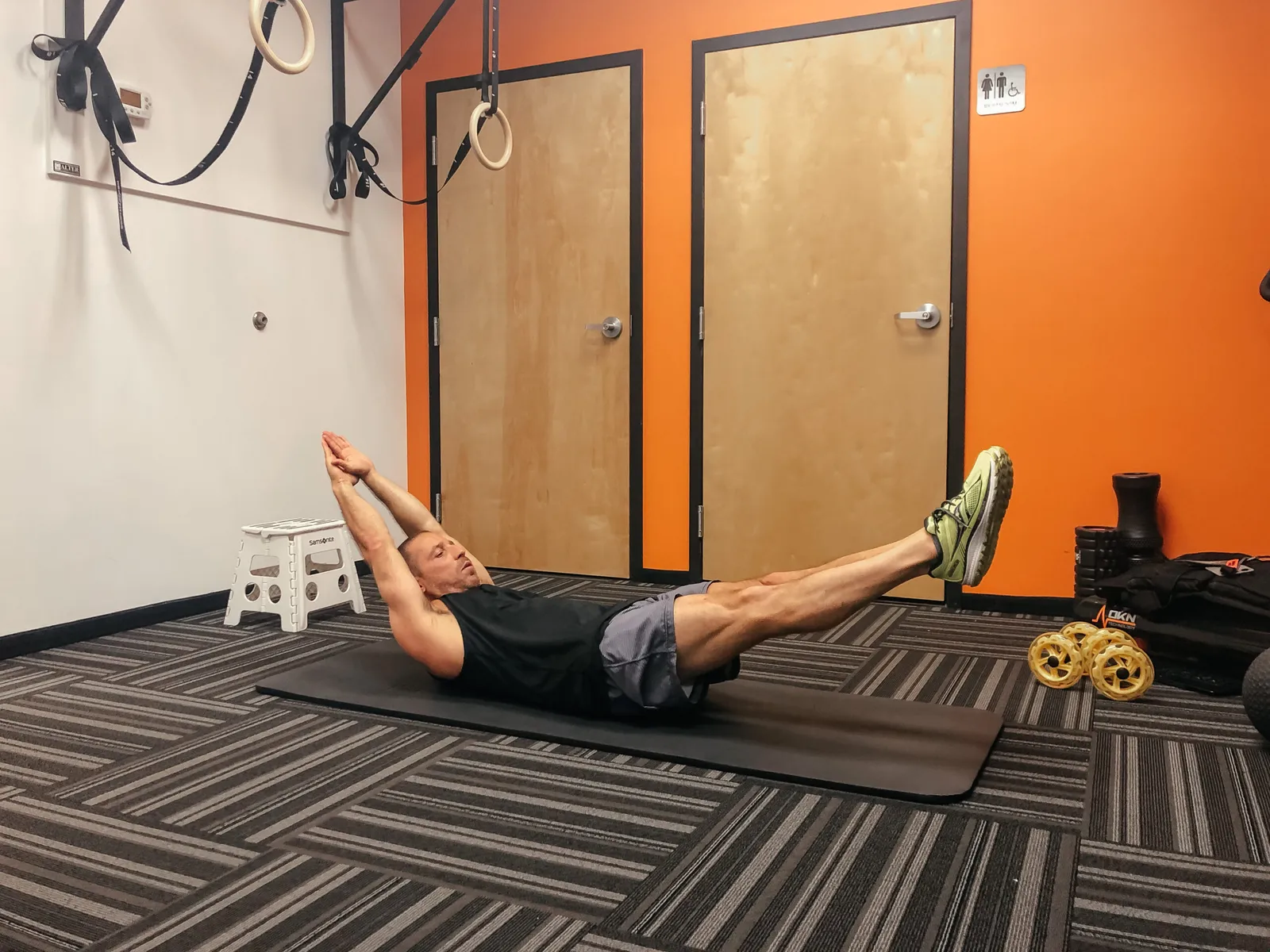 patient doing a core exercise on a mat in the clinic