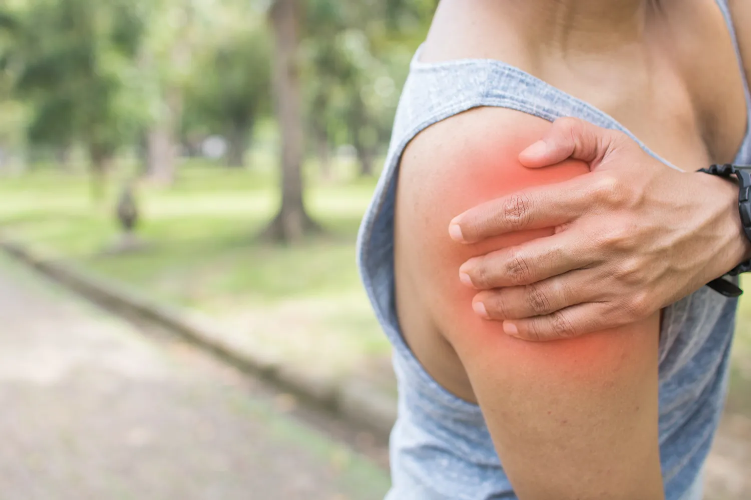 Fitness woman suffering from shoulder injury while exercising