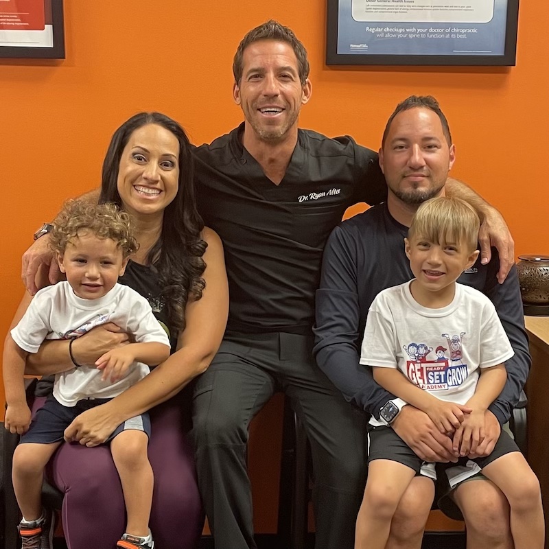 Dr Ryan with smiling family with two young children