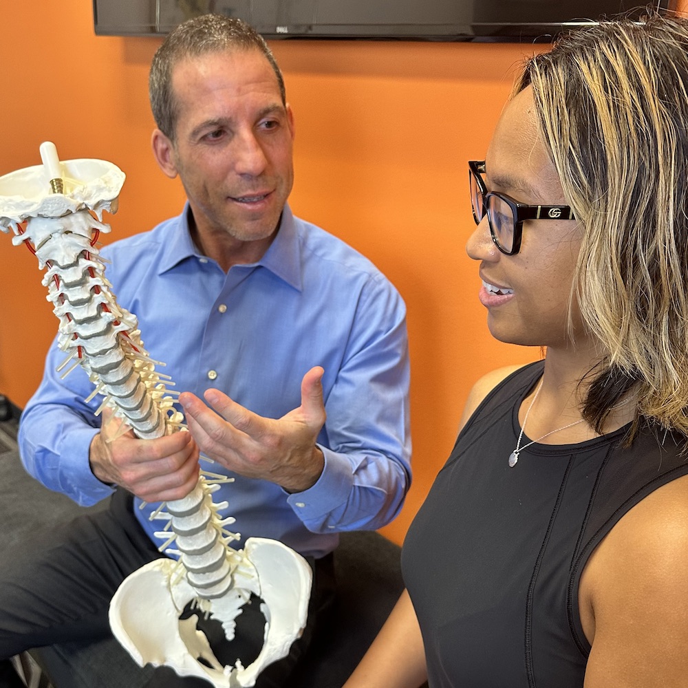 dr ryan showing patient the human spine model