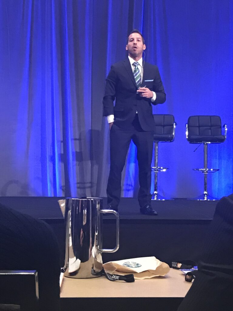 Dr. Ryan Alte wearing a suitr having a speach