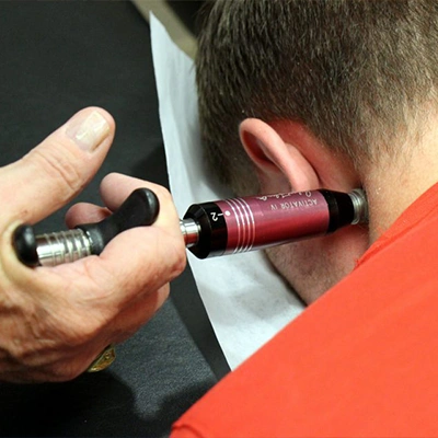 Chiropractic Delray Beach FL Activator Tool Being Used On Patients Neck