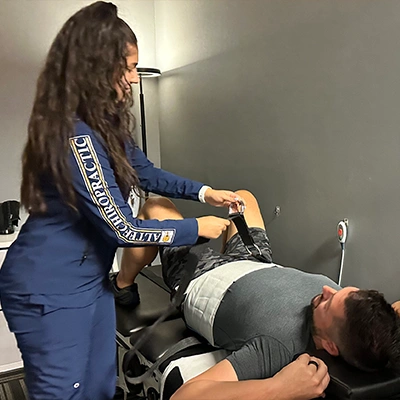 Chiropractic Delray Beach FL Staff Member Helping Patient In Decompression Machine