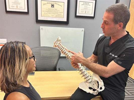 Chiropractor Delray Beach FL Ryan Alter Pointing To Spine First Visit