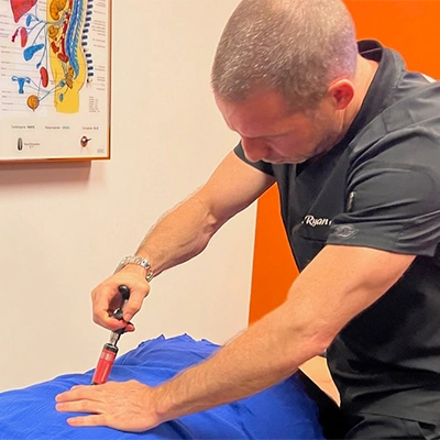 Chiropractor Delray Beach FL Ryan Alter Using Activator Tool On Patient